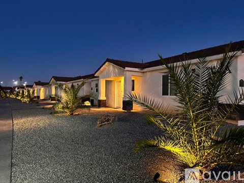 A row of houses with lights on at night.