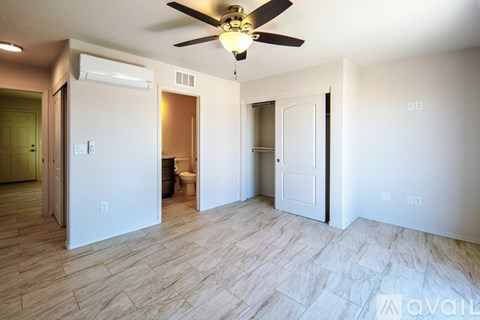 A room with a ceiling fan and tile flooring.