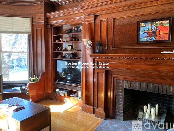 A living room with wood paneling and a fireplace.