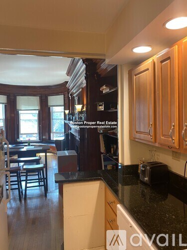 A kitchen with wooden cabinets and a black countertop.
