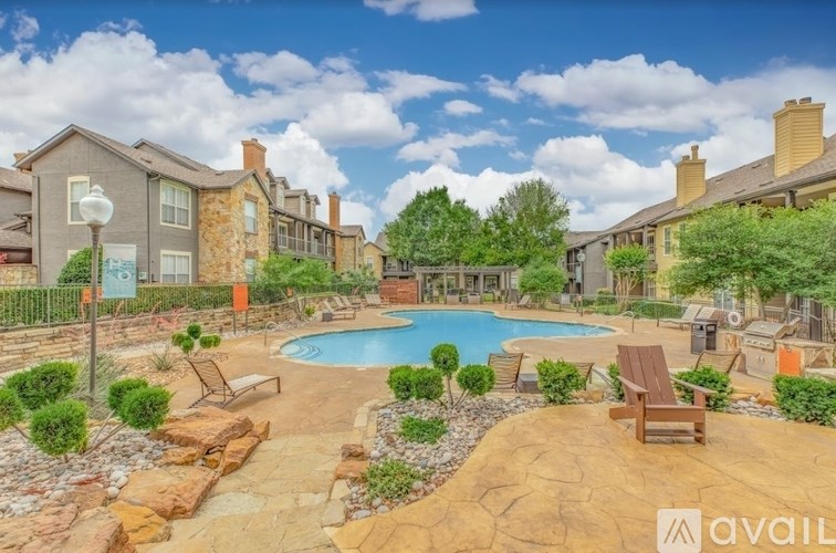 A swimming pool surrounded by a patio with chairs and a fence.