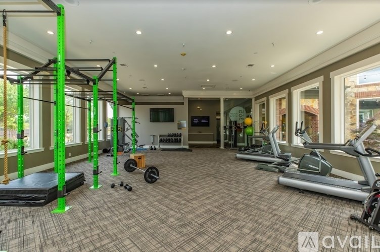A gym with a variety of equipment including treadmills, weights, and a bench press.