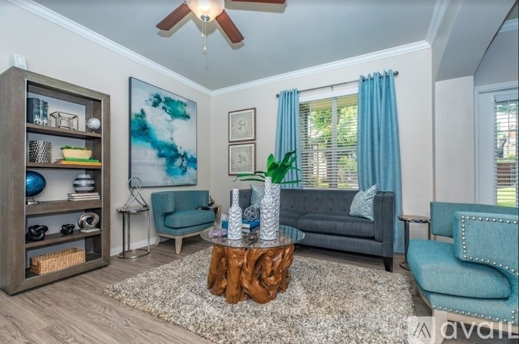 A living room with a grey couch, a wooden coffee table, and a blue chair.
