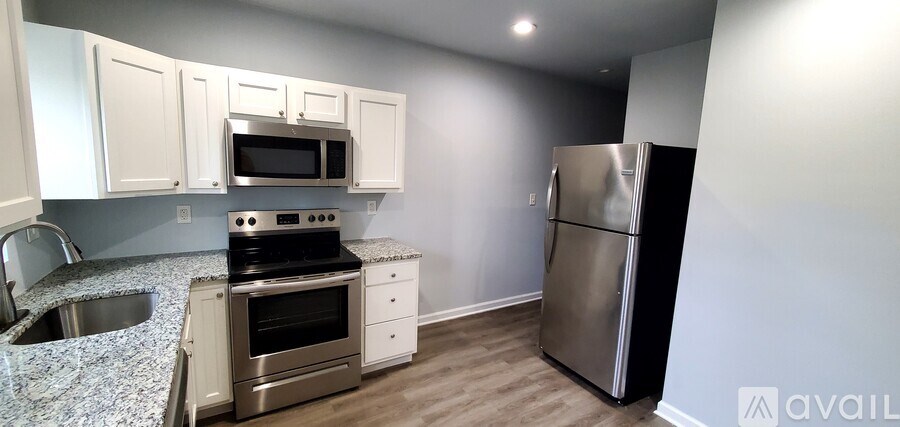 A kitchen with a stove, oven, refrigerator, and sink.