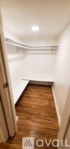 A hallway with a wooden floor and white walls.