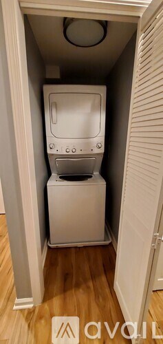 A white washing machine is in a small closet.