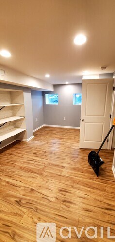 A room with wooden flooring and a vacuum cleaner.
