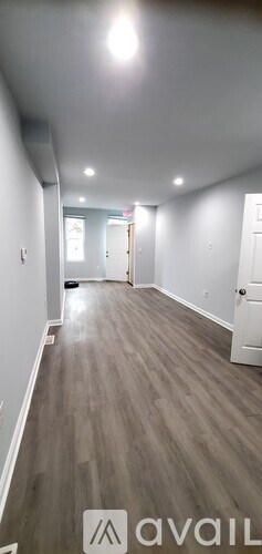 A long hallway with wood floors and white walls.