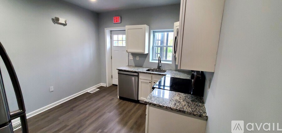 A kitchen with a granite countertop and white cabinets.