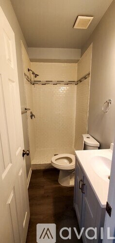A bathroom with a toilet, sink, and shower.