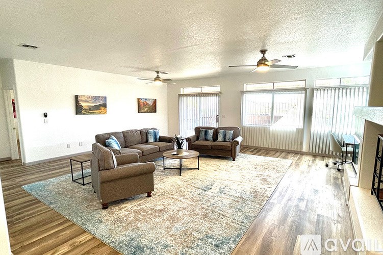 A living room with a couch, a chair, and a rug.
