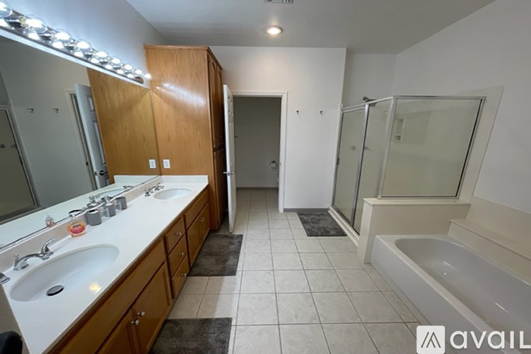 A bathroom with a tub, sink, and mirror.