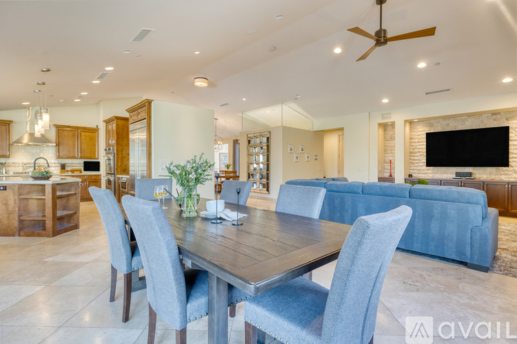 A modern dining room with a wooden table and blue chairs.