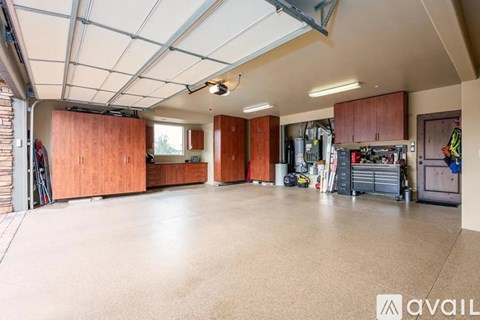 A spacious garage with wooden cabinets and a variety of tools.