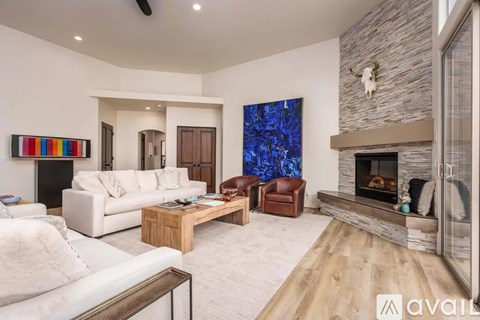 A modern living room with a fireplace and a large painting on the wall.