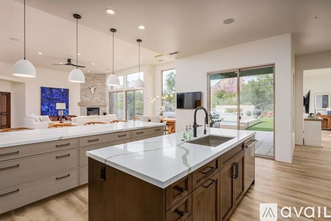 A modern kitchen with a large island and wooden cabinets.