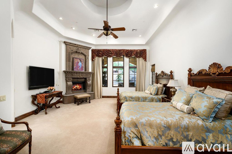 A bedroom with a large bed and a fireplace.