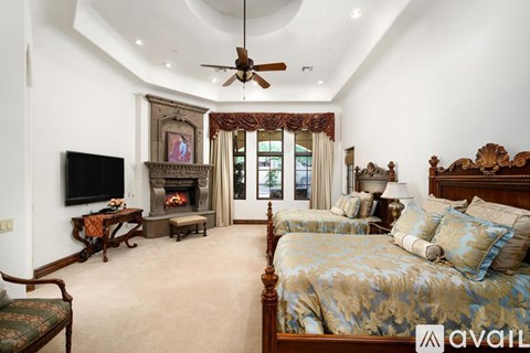 A bedroom with a large bed and a fireplace.