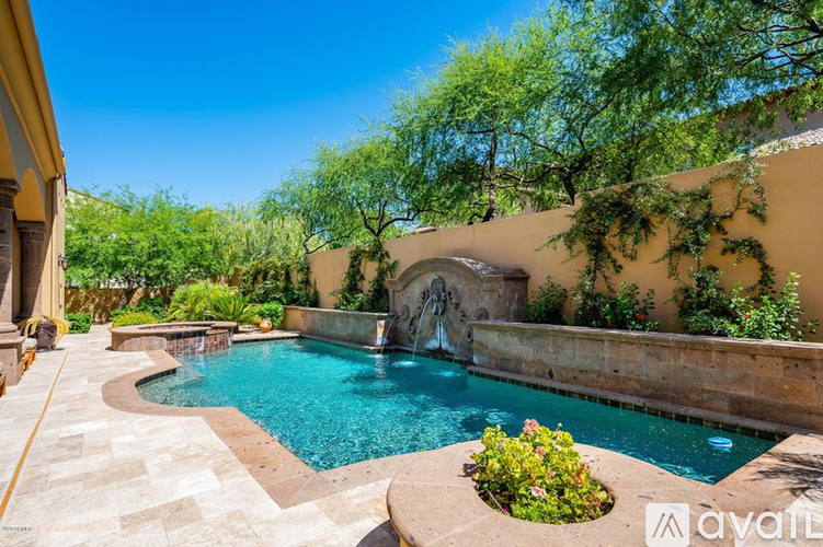 A pool with a waterfall and a stone wall.