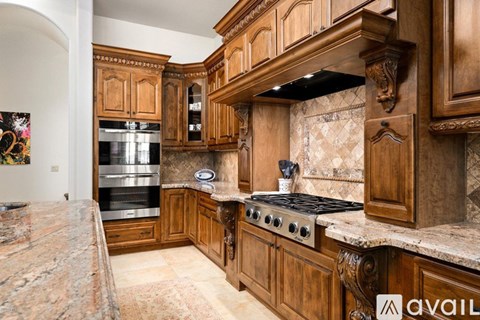 A kitchen with wooden cabinets and a granite countertop.