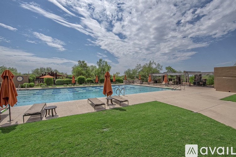 A pool area with lounge chairs and umbrellas.