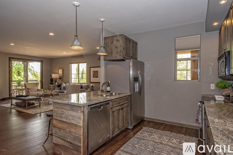 A kitchen with a wooden island and stainless steel appliances.