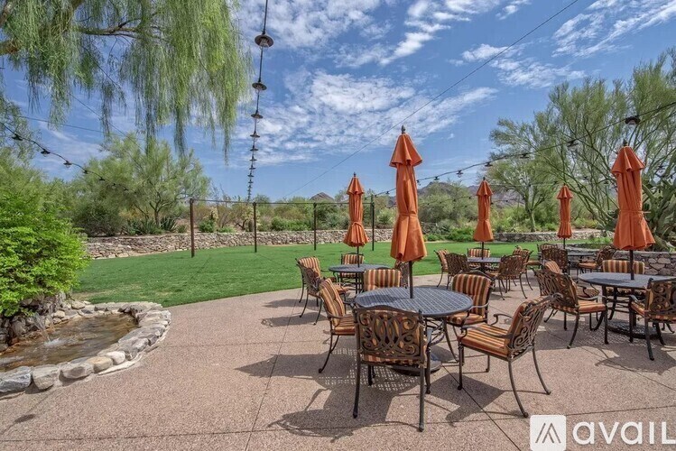 A patio with tables and chairs and umbrellas is available for rent.