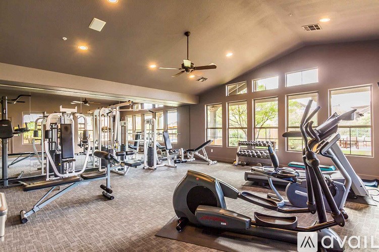 A gym with a variety of equipment including treadmills, weights, and exercise machines.