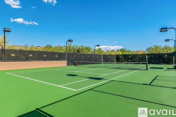 A tennis court with a clear blue sky in the background.