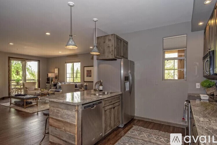 A kitchen with a wooden island and pendant lights.