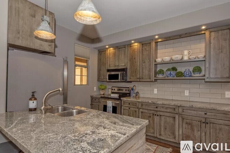 A kitchen with granite countertops and wooden cabinets.