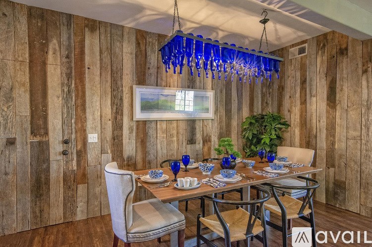 A dining room with a wooden wall and a chandelier.