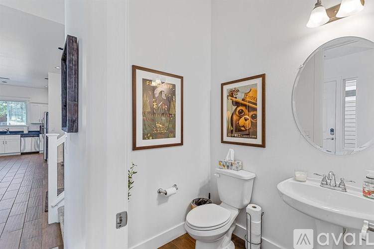 A bathroom with a toilet, sink, and mirror.