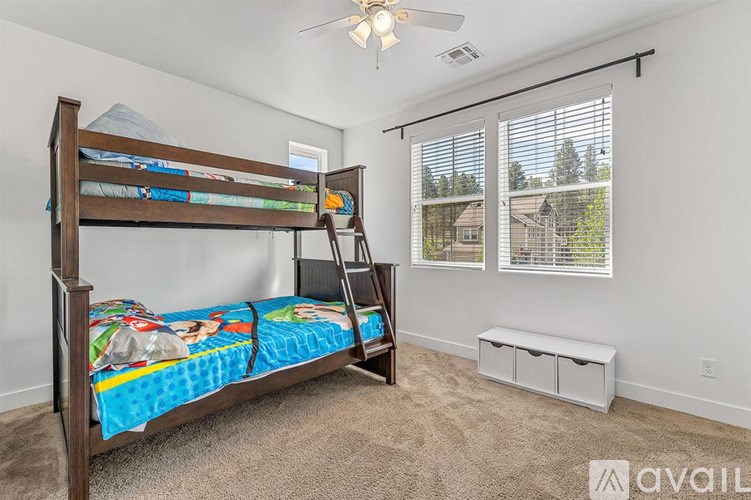 A bedroom with a bunk bed and a window with blinds.