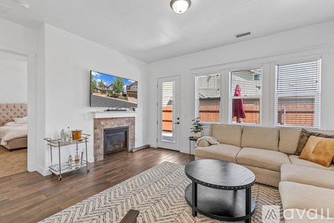 A living room with a fireplace and a television mounted on the wall.