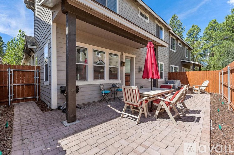 A patio with a table and chairs is set up outside a house.