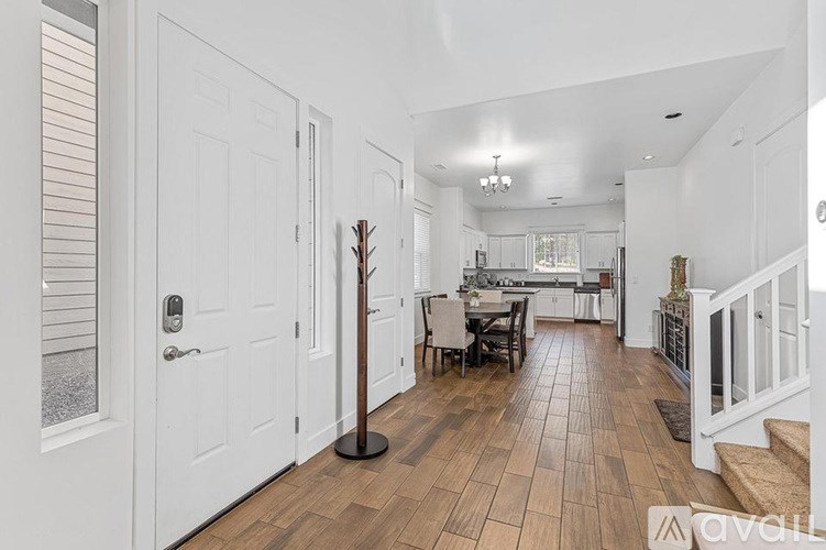 A hallway with a wooden floor and white walls.