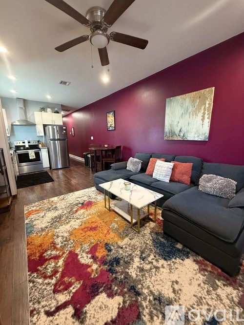 A bedroom with a bed, pillows, and a ceiling fan.