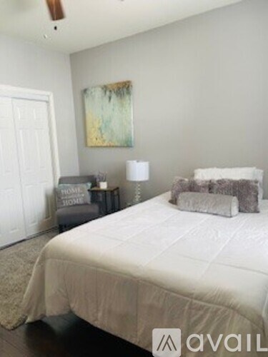 A bedroom with a large bed and a painting on the wall.
