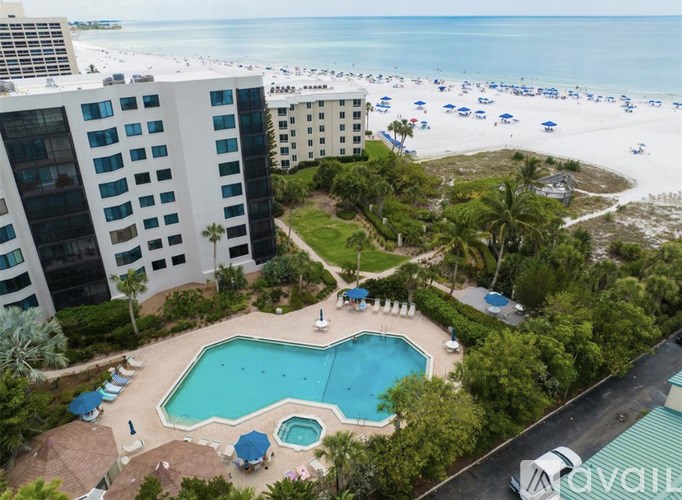 An aerial view of a hotel with a swimming pool and beachfront location.
