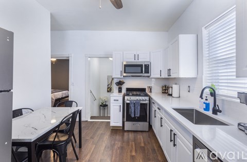 A kitchen with white cabinets and a marble table.
