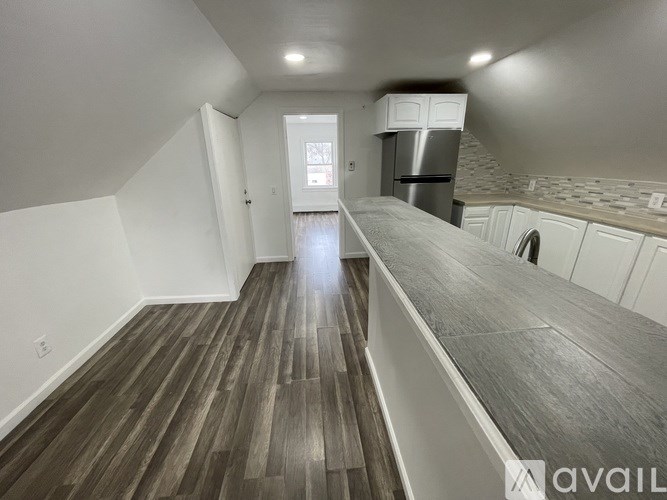A kitchen with a refrigerator and a stove top oven.