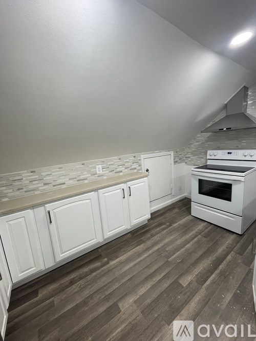 A kitchen with white cabinets and a stove top oven.