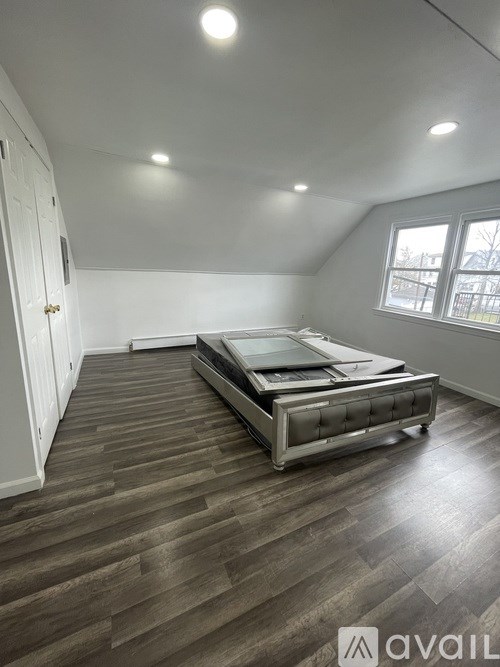 A bedroom with a bed and a window.