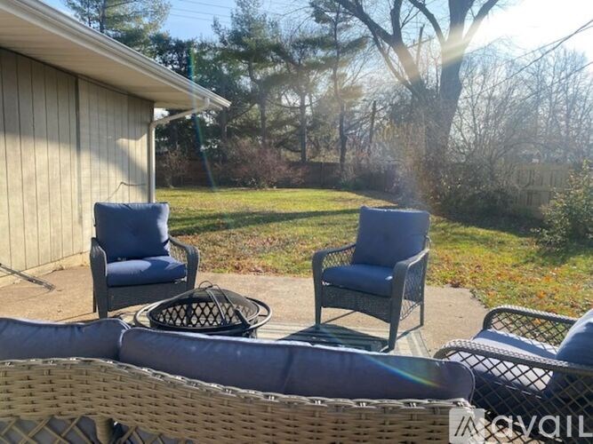 Two chairs and a table are on a patio.