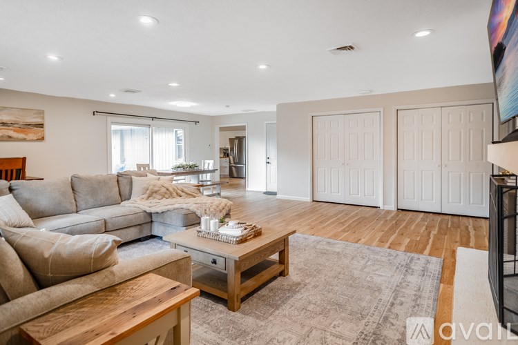 A kitchen with a bowl of red apples on the table.