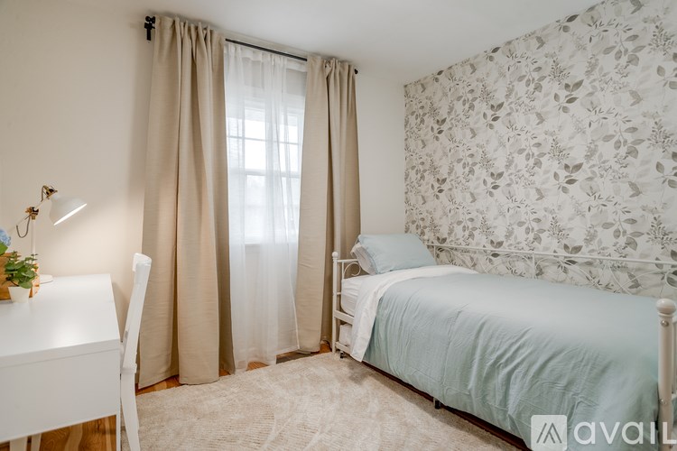 A bedroom with a bed, desk, and chair.