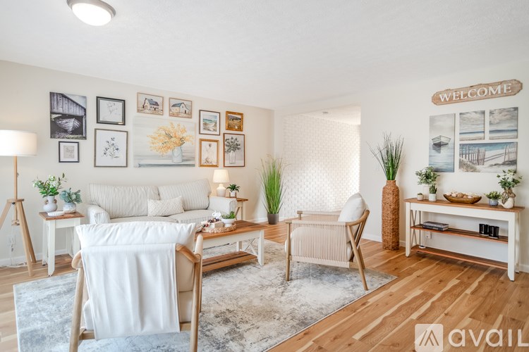 A living room with a white sofa, a wooden coffee table, and a white chair.