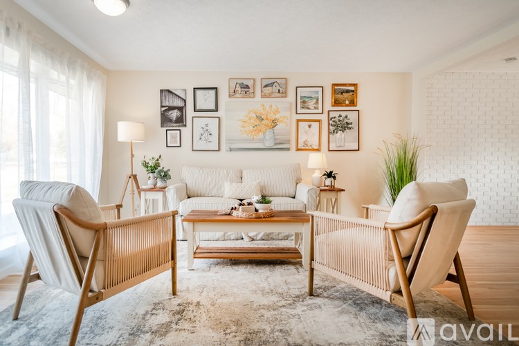 A living room with a sofa, two chairs, and a coffee table.