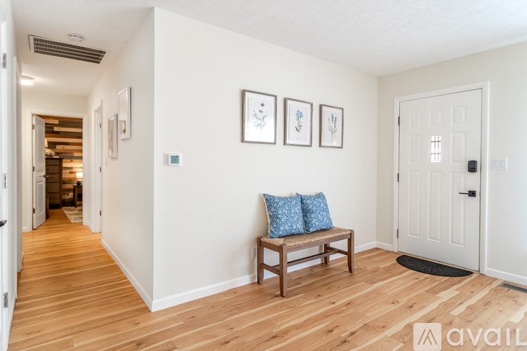 A hallway with a bench and pictures on the wall.